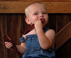 Kid enjoying US Wellness Beef 

Jerky!