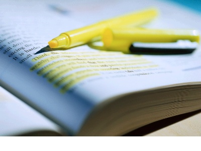 yellow highlighter pen on open book